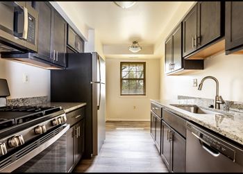 a kitchen with dark cabinets and white countertops at Seminary Roundtop Apartments, Lutherville, MD, 21093